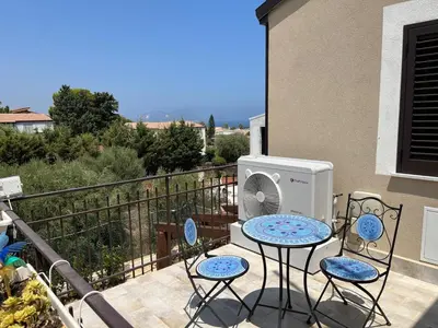 a balcony with a table and chairs and a fan at Casa Vacanze Villa Ale in Altavilla Milicia