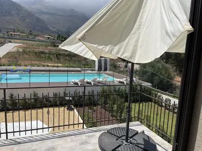 a view of a pool from a balcony with an umbrella at Casa Vacanze Villa Ale in Altavilla Milicia