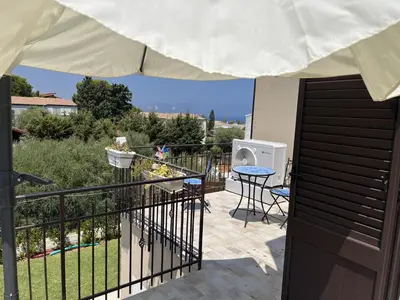a balcony with a table and chairs and an umbrella at Casa Vacanze Villa Ale in Altavilla Milicia