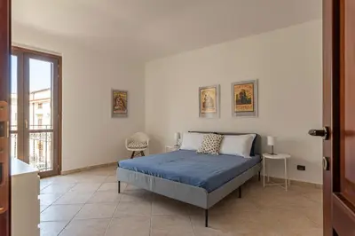 a white bedroom with a bed and a window at The Terrace Behind the Cathedral by Wonderful Italy in Palermo