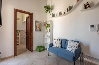a living room with a blue chair and a mirror at The Terrace Behind the Cathedral by Wonderful Italy in Palermo