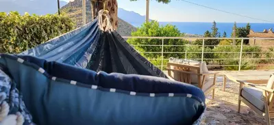 a blue hammock with a view of the ocean at Villa Ballerina Bianca in Scopello