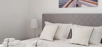 a bedroom with a bed with white pillows at Villa Ballerina Bianca in Scopello