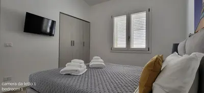 a bedroom with white towels on a bed at Villa Ballerina Bianca in Scopello
