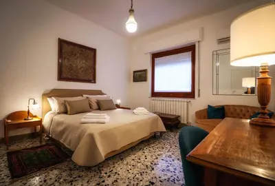 a bedroom with a bed and a table and a couch at Casa Marele in Palermo