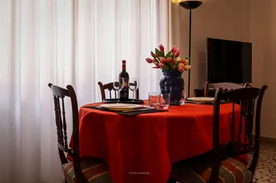a red table with a bottle of wine and flowers on it at Casa Marele in Palermo
