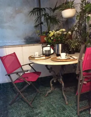 a table with two chairs and a table with flowers on it at Casa Marele in Palermo