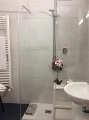 a bathroom with a glass shower and a sink at Casa Marele in Palermo
