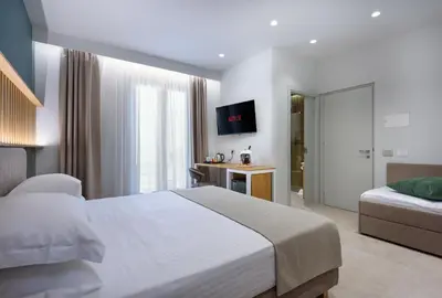 a hotel room with a bed and a television at IL MARE DENTRO SUITES in San Vito lo Capo