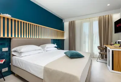 a bedroom with a large bed with a blue wall at IL MARE DENTRO SUITES in San Vito lo Capo