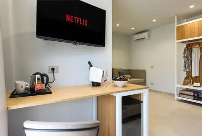 a living room with a desk with a television on the wall at IL MARE DENTRO SUITES in San Vito lo Capo
