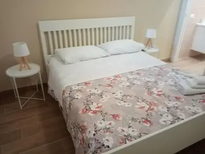 a bedroom with a bed with a floral bedspread at Egea Casa Vacanza in Capaci