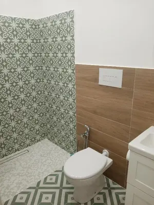 a bathroom with a toilet and a tile wall at Egea Casa Vacanza in Capaci