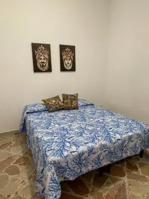 a bed in a room with two pictures on the wall at APPARTAMENTO MAESTRALE in Balestrate