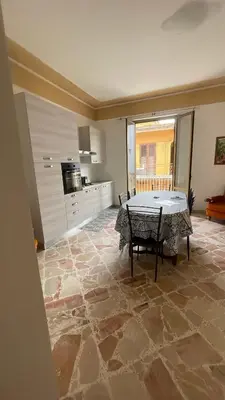 a living room with a table and a kitchen at APPARTAMENTO MAESTRALE in Balestrate