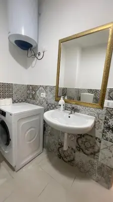 a bathroom with a sink and a washing machine at APPARTAMENTO MAESTRALE in Balestrate