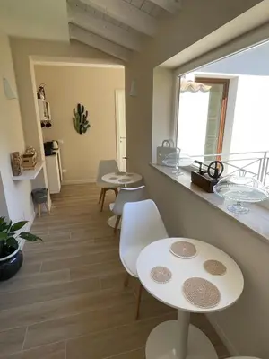 a room with two tables and chairs and a window at Martanna Rooms in Carini