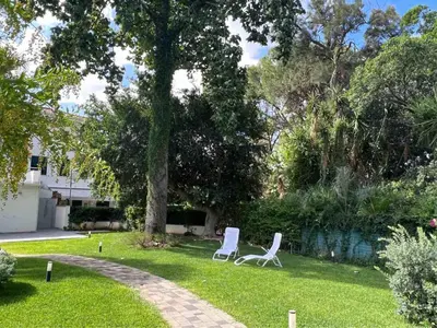 two white chairs in a yard with a tree at La Casa di Dada in Terrasini