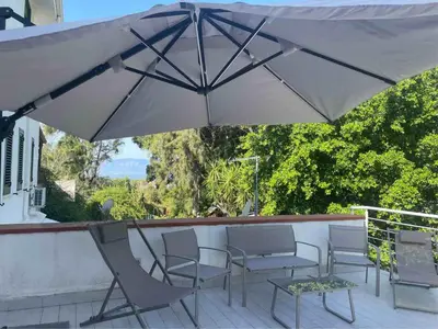 a large white umbrella sitting on a patio at La Casa di Dada in Terrasini
