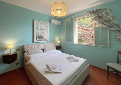 a bedroom with a white bed and a window at Solemar Sicilia - Villa Elis in Bagheria