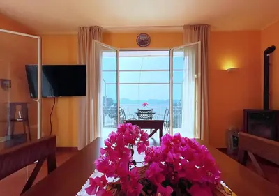 a living room with a table with pink flowers on it at Solemar Sicilia - Villa Elis in Bagheria