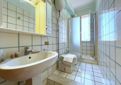 a white bathroom with a sink and a toilet at Solemar Sicilia - Villa Elis in Bagheria