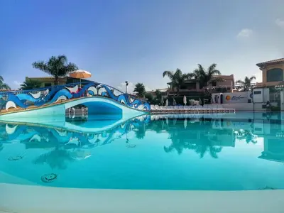 a swimming pool with blue water in a resort at Casa Vacanze Villa Pomelia in Campofelice di Roccella