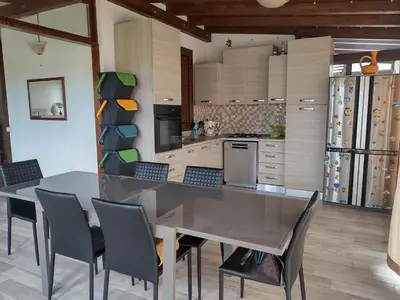 a kitchen with a table and chairs in a room at Casa Vacanze Villa Pomelia in Campofelice di Roccella