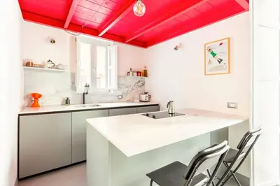 a kitchen with red ceilings and a sink and chairs at A casa di Simona in Palermo