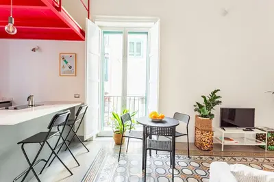 a kitchen and a living room with a table and chairs at A casa di Simona in Palermo