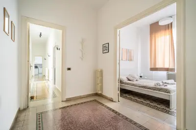 a white room with a bed and a mirror at [La Maiolica] - Centro storico in Palermo