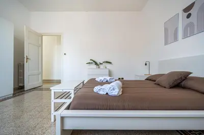 a white bedroom with a bed and a white table at [La Maiolica] - Centro storico in Palermo