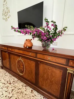 a dresser with a vase of flowers on top of it at Sunny Home in Palermo