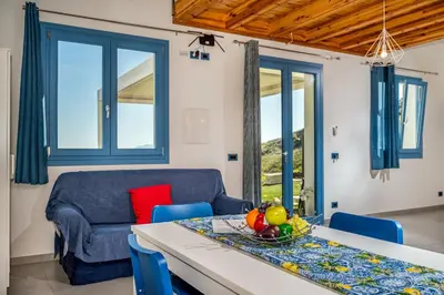 a living room with a table and a couch at Villa Holidays Vista Torre Bennistra in Scopello in Scopello
