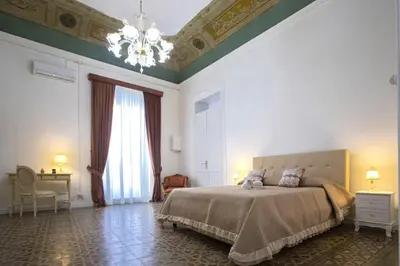 a bedroom with a bed and a chandelier at Terre d'oro, appartamento di lusso in centro città in Palermo