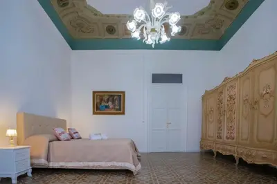 a bedroom with a bed and a chandelier at Terre d'oro, appartamento di lusso in centro città in Palermo