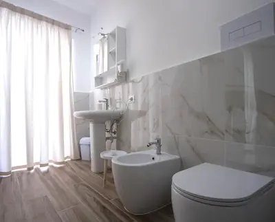 a white bathroom with a toilet and a sink at Terre d'oro, appartamento di lusso in centro città in Palermo