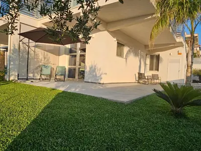 a house with two lawn chairs and an umbrella at Casa vacanze I colori del mare in Alcamo Marina