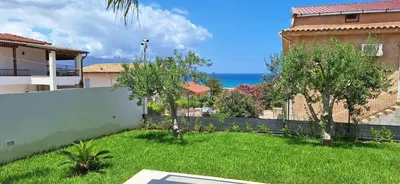 a yard with a fence and the ocean in the background at Casa vacanze I colori del mare in Alcamo Marina