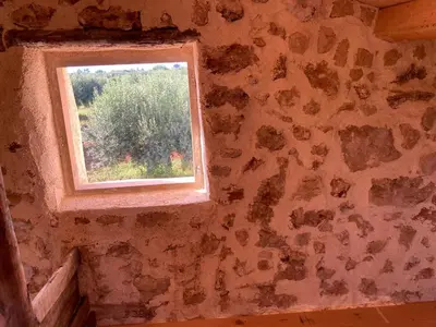 an old room with a window in a stone wall at Lovely Country House in Trappeto