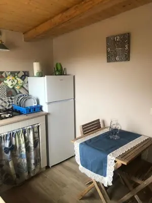a kitchen with a white refrigerator and a table at Lovely Country House in Trappeto