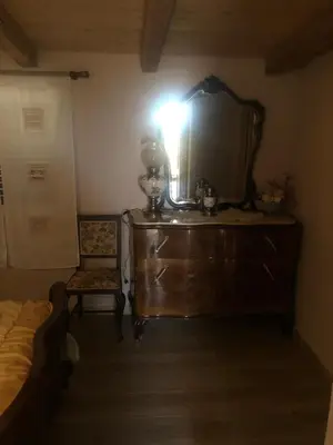 a bedroom with a dresser with a mirror and a chair at Lovely Country House in Trappeto
