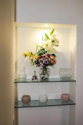 a shelf with a vase with flowers in it at Alexander House in Palermo
