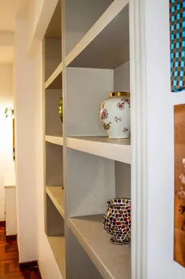 a shelf with a vase and a bowl on it at Alexander House in Palermo