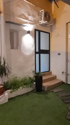 a room with stairs and a window and green grass at Garden Suite Apartment in Palermo