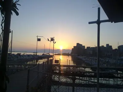 a sunset over a harbor with boats in the water at Casa Vacanza Terrazza sul Mare in Castellammare del Golfo