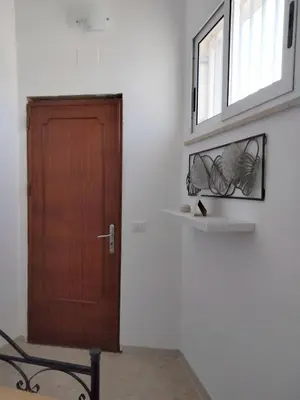 a room with a wooden door and a window at Finestra sul Mare di Alessandro in Balestrate