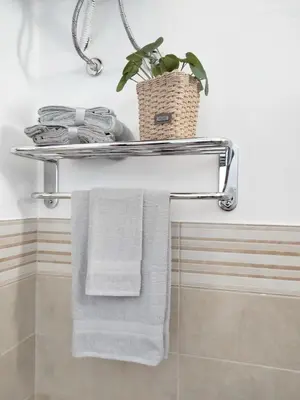a towel rack in a bathroom with towels and a plant at Finestra sul Mare di Alessandro in Balestrate