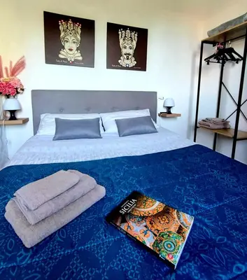 a bed with two towels and a book on it at La casetta degli ulivi in Palermo