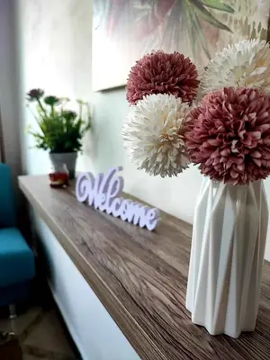 a white vase with red and white flowers on a counter at La casetta degli ulivi in Palermo